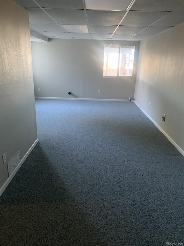 spare room with a paneled ceiling and carpet floors