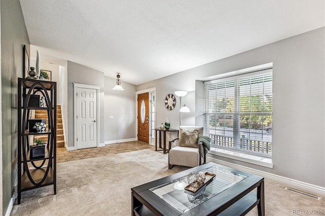 living area with carpet floors, baseboards, and visible vents