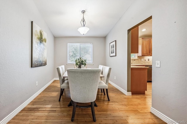 dining room featuring baseboards and light wood finished floors