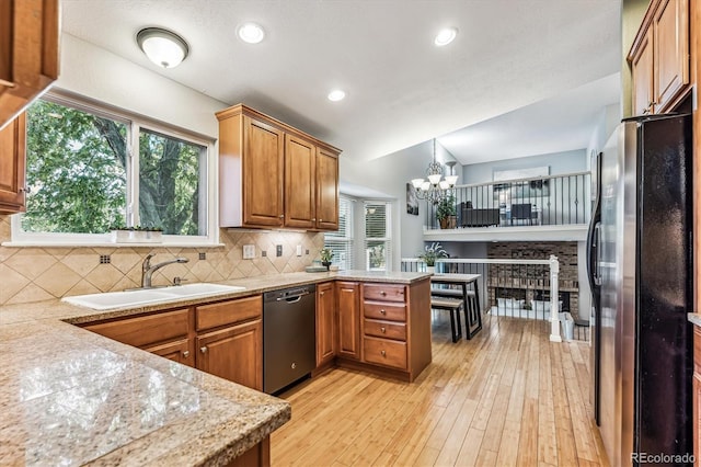 kitchen with dishwasher, backsplash, freestanding refrigerator, light countertops, and a sink