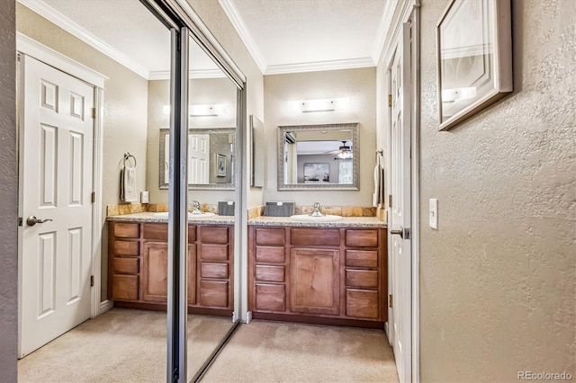 full bath featuring a textured ceiling, a textured wall, ornamental molding, and vanity