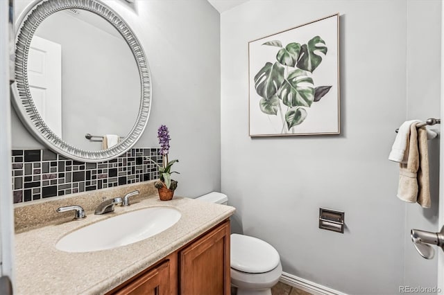 bathroom featuring vanity, backsplash, and toilet