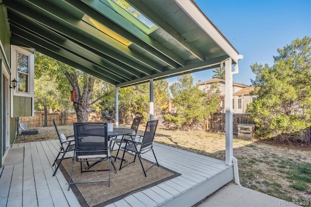 wooden terrace with outdoor dining space and a fenced backyard