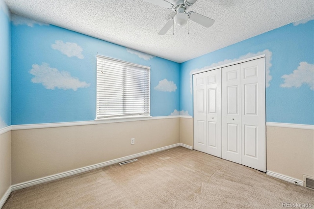 unfurnished bedroom with carpet floors, a textured ceiling, visible vents, and a closet