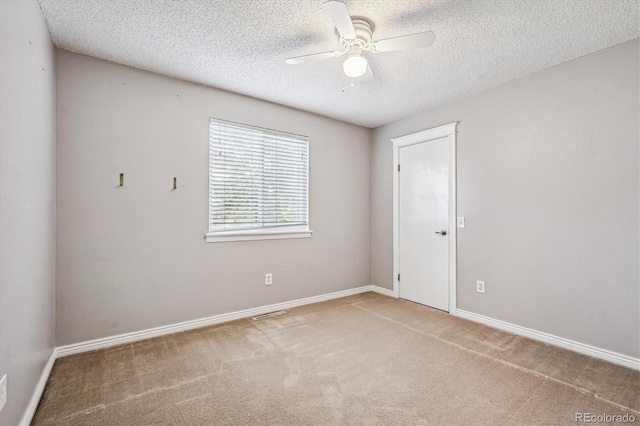 unfurnished room with a textured ceiling, carpet floors, ceiling fan, and baseboards