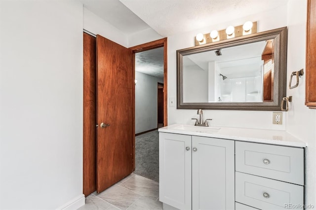 full bath featuring baseboards, a textured ceiling, and vanity