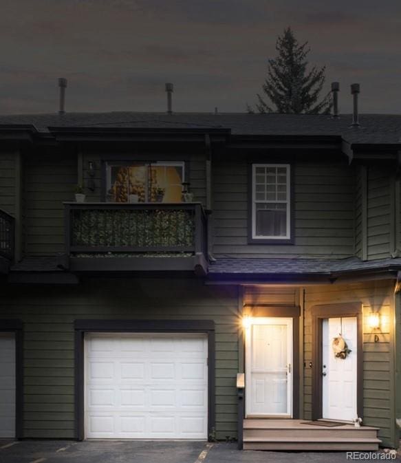 view of front of property featuring a balcony and a garage