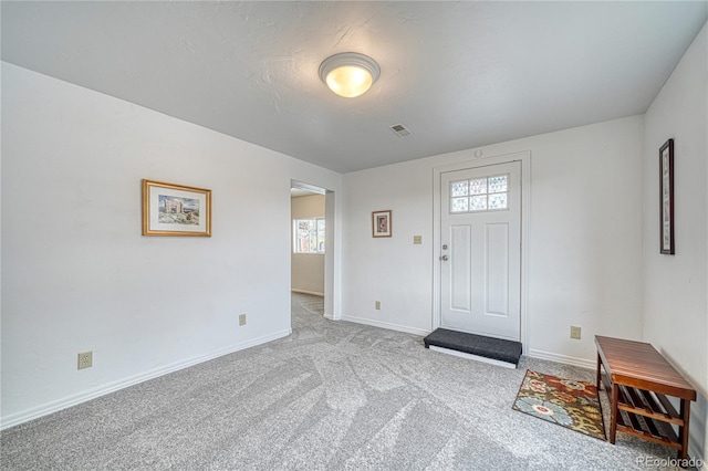 carpeted entrance foyer featuring visible vents and baseboards