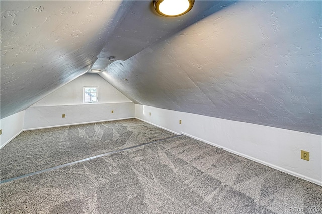 bonus room featuring baseboards, lofted ceiling, carpet, and a textured ceiling