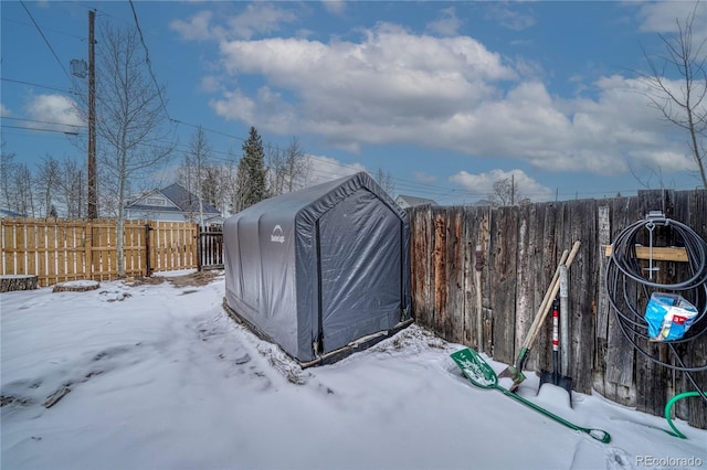 snow covered structure featuring fence