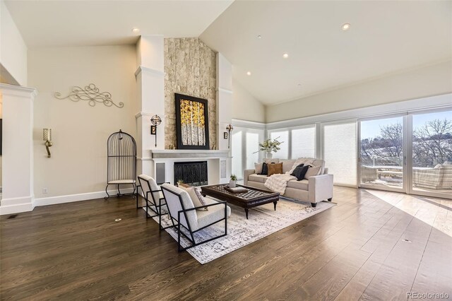 living room featuring a fireplace, hardwood / wood-style flooring, and high vaulted ceiling