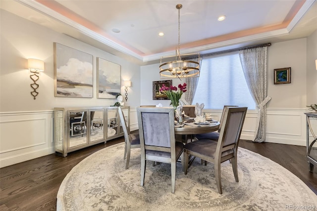 dining room featuring dark hardwood / wood-style flooring, an inviting chandelier, and a raised ceiling