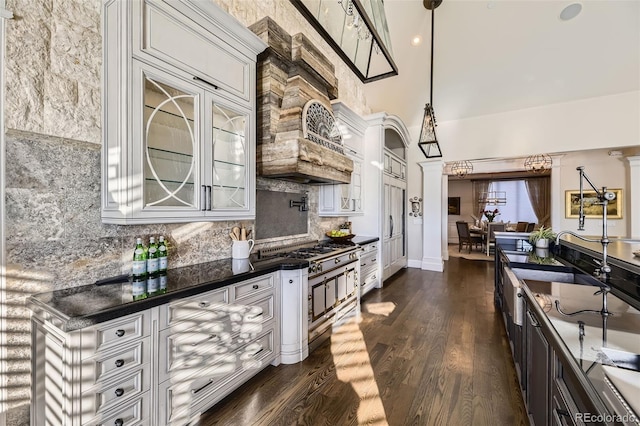 kitchen with tasteful backsplash, white cabinetry, dark hardwood / wood-style flooring, and decorative light fixtures