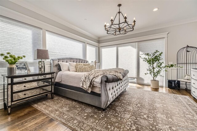 bedroom featuring crown molding, dark hardwood / wood-style flooring, a baseboard heating unit, and an inviting chandelier