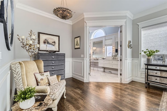 sitting room featuring dark hardwood / wood-style floors, an inviting chandelier, and crown molding