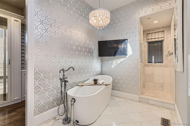 bathroom with plus walk in shower and a chandelier