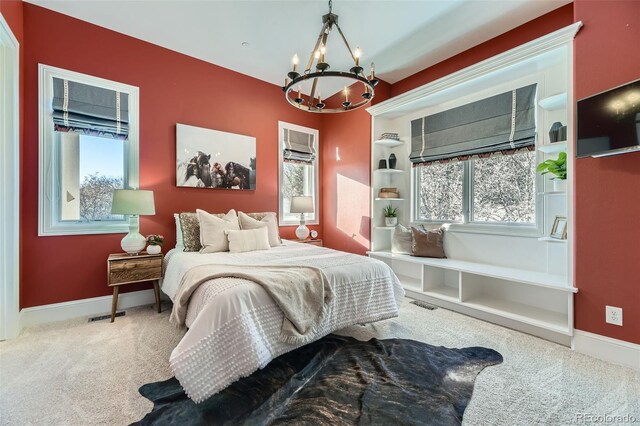 carpeted bedroom with multiple windows and a notable chandelier