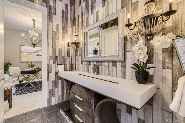 bathroom featuring tile patterned floors, sink, and a notable chandelier