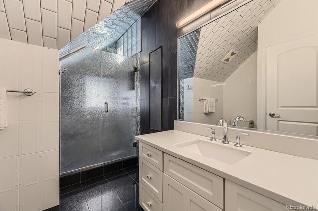 bathroom with a shower, vanity, and vaulted ceiling