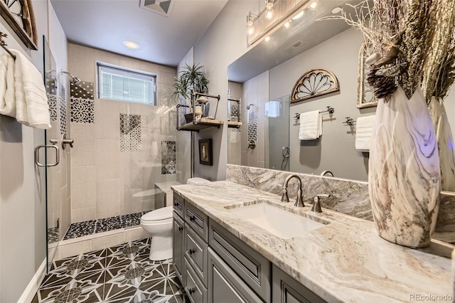 bathroom with tile patterned flooring, vanity, toilet, and a shower with door