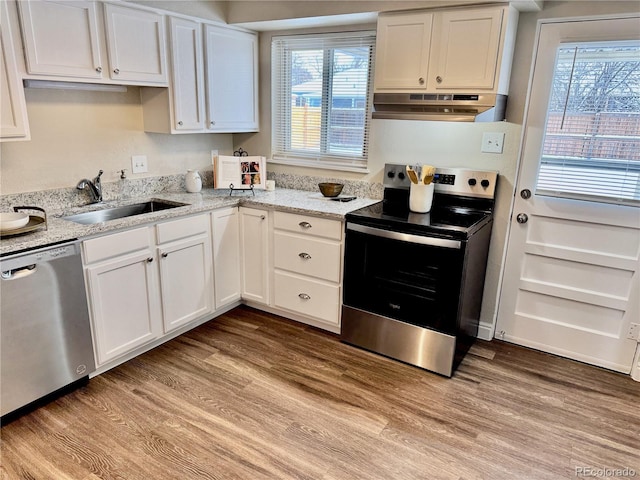 kitchen featuring sink, light hardwood / wood-style flooring, stainless steel appliances, light stone countertops, and white cabinets