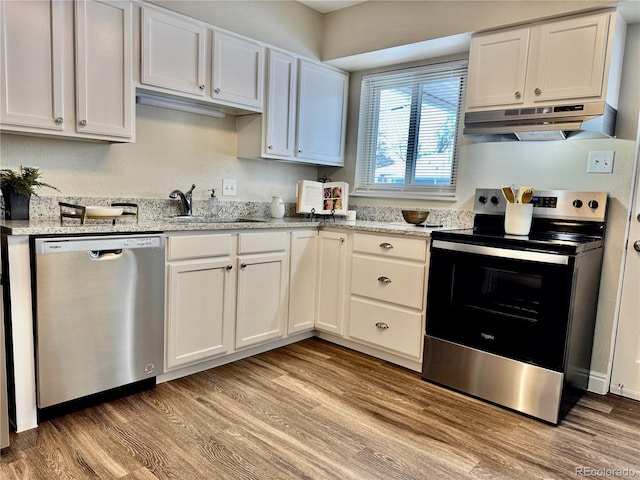 kitchen featuring appliances with stainless steel finishes, light stone countertops, and white cabinets