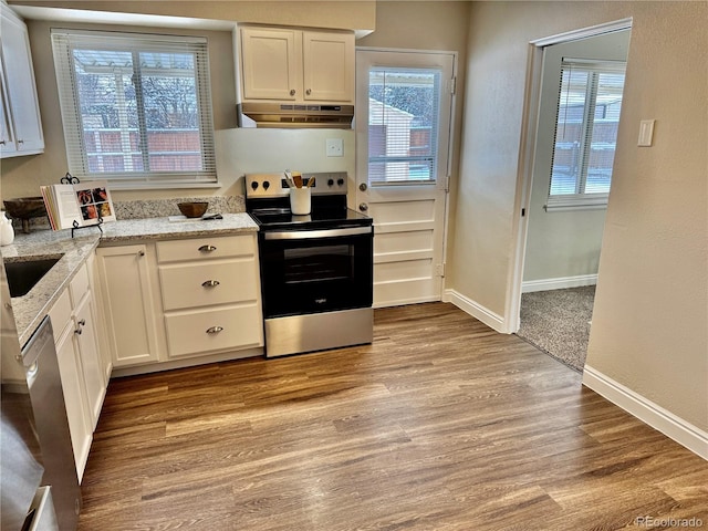 kitchen featuring white cabinetry, appliances with stainless steel finishes, light stone countertops, and light hardwood / wood-style floors