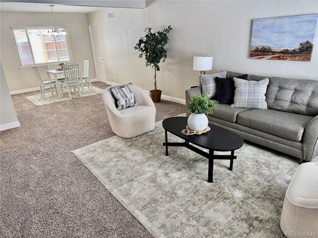 carpeted living room with a chandelier