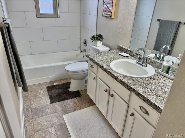 full bathroom featuring tiled shower / bath, vanity, and toilet