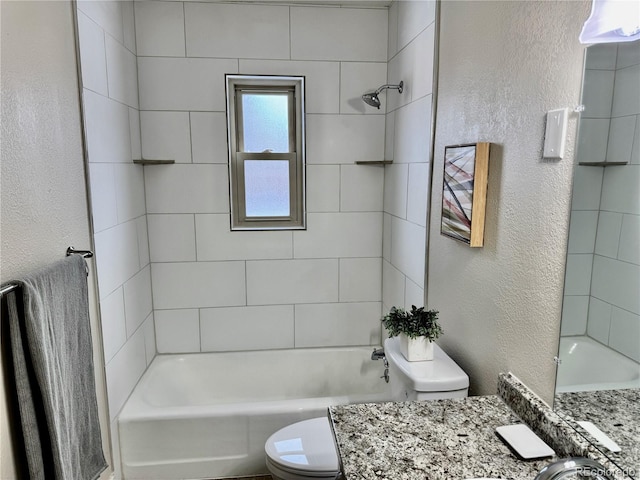 full bathroom featuring vanity, tiled shower / bath, and toilet