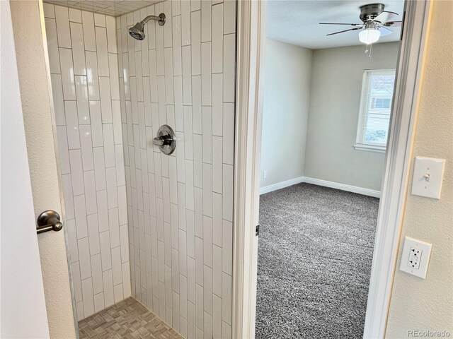 bathroom with tiled shower and ceiling fan