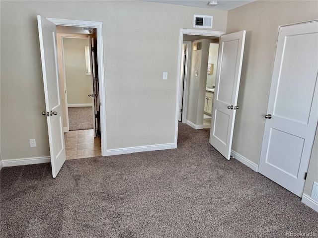 unfurnished bedroom with dark colored carpet