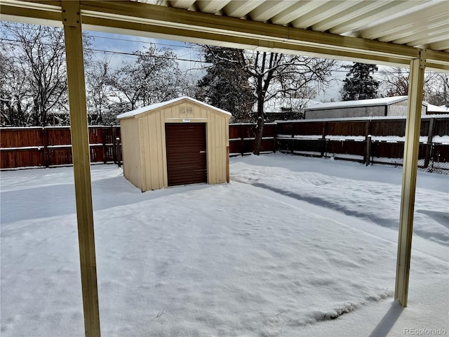 yard covered in snow featuring a storage shed