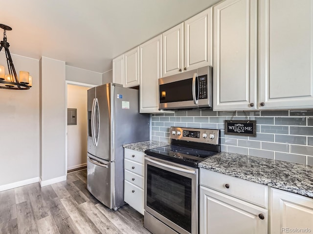 10736 Logan Ct, Northglenn, CO 80233 - kitchen with appliances with stainless steel finishes, a chandelier, light wood-style floors, and tasteful backsplash