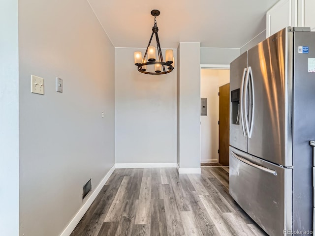 10736 Logan Ct, Northglenn, CO 80233 - kitchen with stainless steel fridge, a chandelier, white cabinetry, and wood finished floors