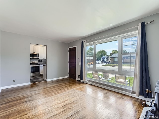 10736 Logan Ct, Northglenn, CO 80233 - unfurnished living room featuring baseboards and wood finished floors