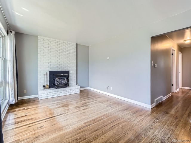 10736 Logan Ct, Northglenn, CO 80233 - unfurnished living room with wood finished floors and a brick fireplace