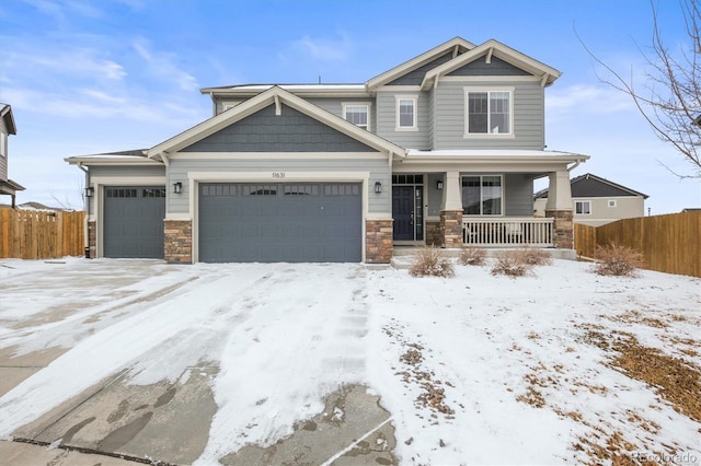 craftsman-style home with an attached garage, covered porch, stone siding, and fence