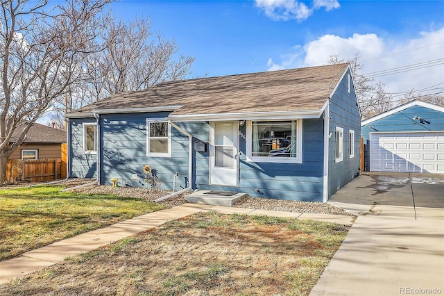 bungalow-style home featuring a garage and an outbuilding