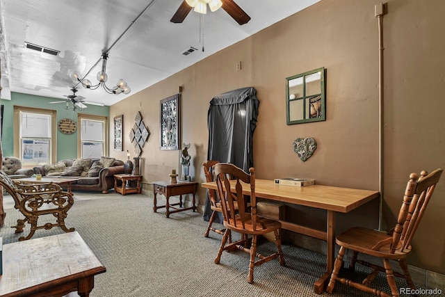 dining room featuring ceiling fan with notable chandelier and carpet flooring