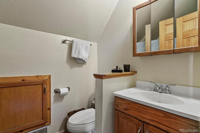 bathroom featuring lofted ceiling, vanity, and toilet