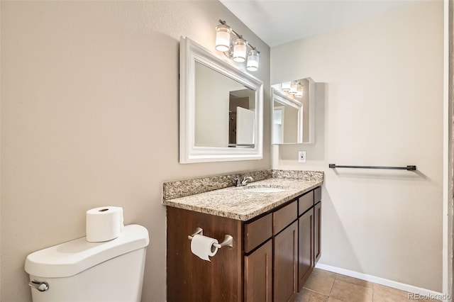 bathroom with toilet, tile patterned floors, baseboards, and vanity