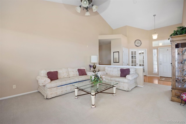 carpeted living room with a high ceiling, a ceiling fan, and baseboards