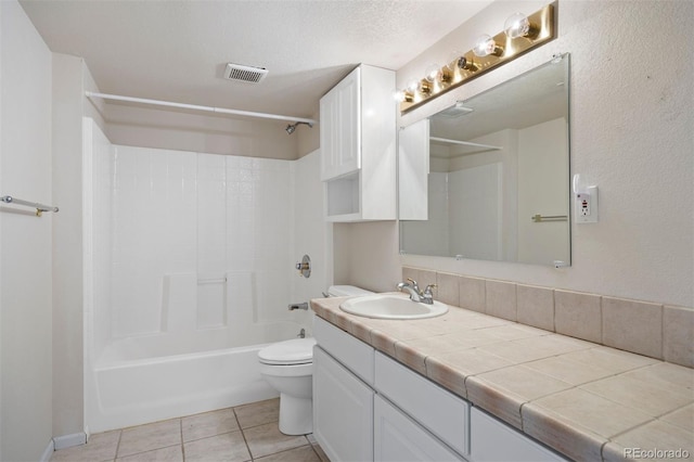 bathroom featuring tile patterned floors, toilet, vanity, and bathtub / shower combination