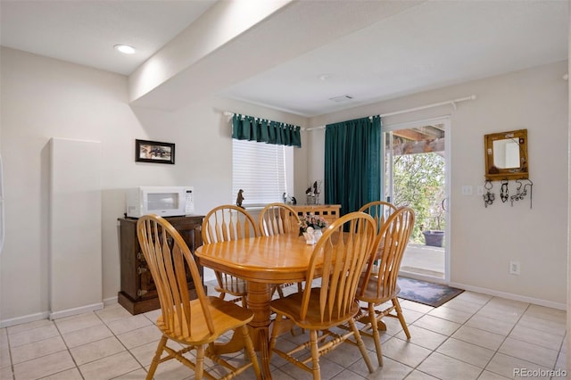 dining space featuring light tile patterned floors and baseboards