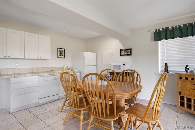 dining space featuring light tile patterned flooring and baseboards