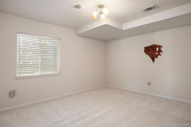 spare room with light colored carpet, baseboards, and a smoke detector