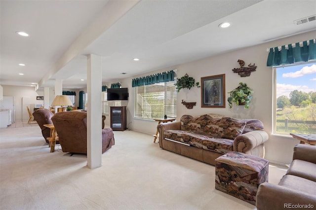 living room featuring light colored carpet, healthy amount of natural light, recessed lighting, and a glass covered fireplace