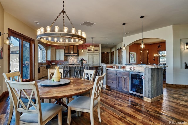 dining room with wine cooler, dark wood-type flooring, and sink