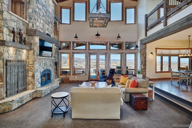 carpeted living room with a fireplace, a high ceiling, and a notable chandelier